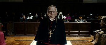 Movie still from “The Great Beauty” (2013), directed by Paolo Sorrentino – An old man wearing a priest's outfit in front of a group of people; Medium shot, Low angle