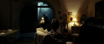 Movie still from “The Great Beauty” (2013), directed by Paolo Sorrentino – A woman sitting on a couch in a living room; Wide shot, Over the shoulder angle