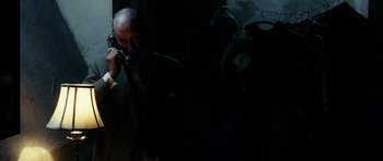 Movie still from “The Great Beauty” (2013), directed by Paolo Sorrentino – An older man talking on a phone in a dark room; Medium shot, High angle