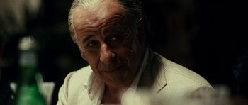 Movie still from “The Great Beauty” (2013), directed by Paolo Sorrentino – An older man in a white jacket looking at the camera; Close Up shot, Over the shoulder angle