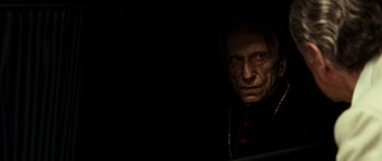 Movie still from “The Great Beauty” (2013), directed by Paolo Sorrentino – An old man wearing a priest's outfit in the dark; Close Up shot, Over the shoulder angle