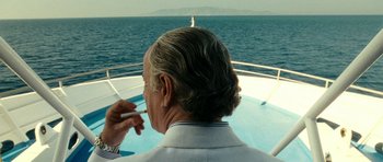 Movie still from “The Great Beauty” (2013), directed by Paolo Sorrentino – An older man with long grey hair is on a boat in front of the ocean; Close Up shot, Over the shoulder angle