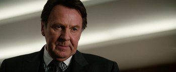 Movie still from “The Green Hornet” (2011), directed by Michel Gondry – An older man in a suit and tie looking at the camera; Close Up shot, Over the shoulder angle