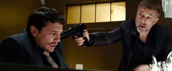 Movie still from “The Green Hornet” (2011), directed by Michel Gondry – A man and a woman holding a gun in a room; Medium shot, Over the shoulder angle