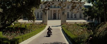Movie still from “The Green Hornet” (2011), directed by Michel Gondry – A man riding a motorcycle down the middle of a road; Extreme Wide shot, High angle