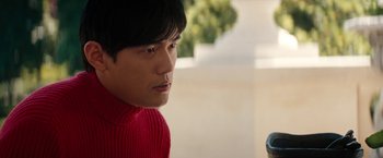 Movie still from “The Green Hornet” (2011), directed by Michel Gondry – A man in a red sweater is looking at the camera; Close Up shot, Over the shoulder angle