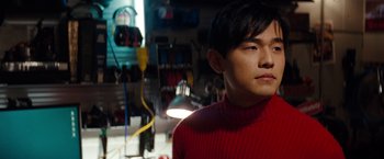 Movie still from “The Green Hornet” (2011), directed by Michel Gondry – A man wearing a red sweater standing in a room; Close Up shot, Low angle