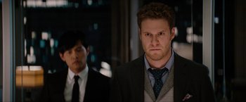 Movie still from “The Green Hornet” (2011), directed by Michel Gondry – A man in a suit and tie standing next to another man in a suit and tie; Close Up shot, Over the shoulder angle