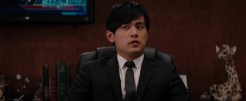 Movie still from “The Green Hornet” (2011), directed by Michel Gondry – A man wearing a suit and tie sitting in a chair; Close Up shot, Over the shoulder angle