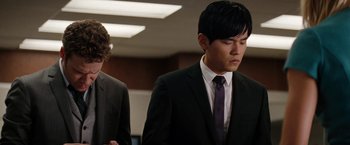 Movie still from “The Green Hornet” (2011), directed by Michel Gondry – A man in a suit standing next to another man in a suit; Medium shot, Over the shoulder angle