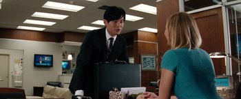 Movie still from “The Green Hornet” (2011), directed by Michel Gondry – A man in a suit and tie holding a briefcase; Medium shot, Over the shoulder angle
