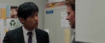 Movie still from “The Green Hornet” (2011), directed by Michel Gondry – Two men in suits talking to each other in front of a refrigerator; Close Up shot, Over the shoulder angle