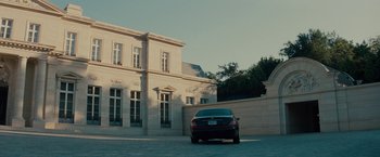 Movie still from “The Green Hornet” (2011), directed by Michel Gondry – A car parked in front of a large building; Extreme Wide shot, Low angle