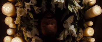 Movie still from “The Green Hornet” (2011), directed by Michel Gondry – A person with their eyes closed surrounded by white flowers; Extreme Close Up shot, Overhead angle
