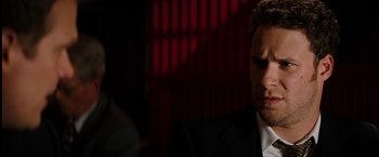 Movie still from “The Green Hornet” (2011), directed by Michel Gondry – A man wearing a suit and tie in a dark room; Close Up shot, Over the shoulder angle