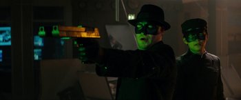 Movie still from “The Green Hornet” (2011), directed by Michel Gondry – A man dressed as the green hornet holding a gun; Close Up shot, Over the shoulder angle
