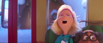 Movie still from “The Grinch” (2018), directed by Yarrow Cheney – A woman with blonde hair is yawning while sitting on a bus; Close Up shot, Low angle