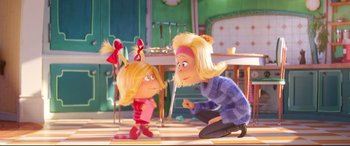 Movie still from “The Grinch” (2018), directed by Yarrow Cheney – A woman and a girl are standing next to each other; Medium shot, Over the shoulder angle