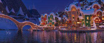 Movie still from “The Grinch” (2018), directed by Yarrow Cheney – A view of a lake with a lot of buildings in the background; Extreme Wide shot, High angle