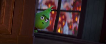 Movie still from “The Grinch” (2018), directed by Yarrow Cheney – A green stuffed animal looking out of a window; Close Up shot, Over the shoulder angle
