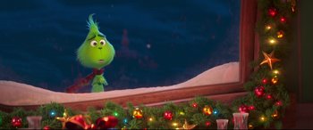 Movie still from “The Grinch” (2018), directed by Yarrow Cheney – The grinch is standing in front of a christmas tree; Medium shot, Over the shoulder angle