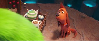 Movie still from “The Grinch” (2018), directed by Yarrow Cheney – A dog sitting in front of a table with a teapot and cups on it; Close Up shot, Over the shoulder angle