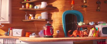 Movie still from “The Grinch” (2018), directed by Yarrow Cheney – A red tea kettle sitting on top of a wooden table; Wide shot, High angle