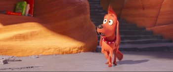 Movie still from “The Grinch” (2018), directed by Yarrow Cheney – A dog with a red collar standing on the ground; Wide shot, High angle