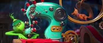 Movie still from “The Grinch” (2018), directed by Yarrow Cheney – A green sewing machine with buttons on the side of it; Extreme Close Up shot, Overhead angle