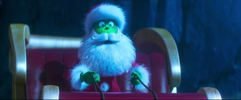 Movie still from “The Grinch” (2018), directed by Yarrow Cheney – A stuffed grinch is sitting in a chair; Medium shot, Low angle