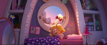 Movie still from “The Grinch” (2018), directed by Yarrow Cheney – A girl is sitting on a bed in front of a mirror; Medium shot, Over the shoulder angle