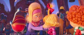 Movie still from “The Grinch” (2018), directed by Yarrow Cheney – A woman holding a child's head with a red bow on it; Close Up shot, Over the shoulder angle