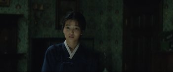 Movie still from “The Handmaiden” (2016), directed by Park Chan-wook – A young asian woman in a black and white outfit; Close Up shot, Over the shoulder angle