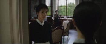 Movie still from “The Handmaiden” (2016), directed by Park Chan-wook – A woman standing in front of two other women; Medium shot, Over the shoulder angle