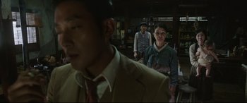 Movie still from “The Handmaiden” (2016), directed by Park Chan-wook – A group of people standing around in a room; Medium shot, Over the shoulder angle