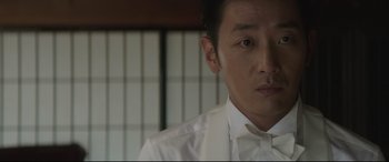 Movie still from “The Handmaiden” (2016), directed by Park Chan-wook – A person wearing a shirt and tie; Close Up shot, Over the shoulder angle