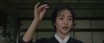 Movie still from “The Handmaiden” (2016), directed by Park Chan-wook – A young woman holding a key in her hand; Close Up shot, High angle