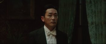 Movie still from “The Handmaiden” (2016), directed by Park Chan-wook – A person wearing a suit and a bow tie; Close Up shot, Low angle