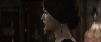 Movie still from “The Handmaiden” (2016), directed by Park Chan-wook – A woman with a black dress and a black and silver earring; Close Up shot, Over the shoulder angle