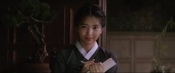Movie still from “The Handmaiden” (2016), directed by Park Chan-wook – A young asian woman holding a piece of paper in her hand; Close Up shot, Over the shoulder angle