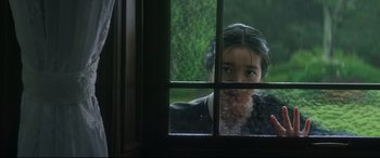 Movie still from “The Handmaiden” (2016), directed by Park Chan-wook – A girl looking out of a window at the rain; Close Up shot, Over the shoulder angle