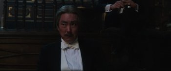 Movie still from “The Handmaiden” (2016), directed by Park Chan-wook – A man wearing a tuxedo and a white bow tie; Close Up shot, Low angle