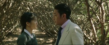Movie still from “The Handmaiden” (2016), directed by Park Chan-wook – A man and a woman standing next to each other in front of trees; Medium shot, Over the shoulder angle