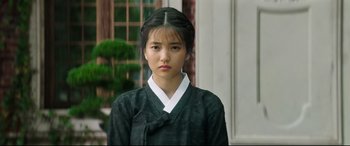 Movie still from “The Handmaiden” (2016), directed by Park Chan-wook – A young asian woman in traditional clothing; Close Up shot, Over the shoulder angle