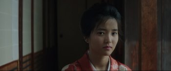 Movie still from “The Handmaiden” (2016), directed by Park Chan-wook – A young woman in a red and white kimono is posing for a picture; Close Up shot, Over the shoulder angle