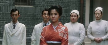 Movie still from “The Handmaiden” (2016), directed by Park Chan-wook – A group of people standing next to each other; Medium shot, Over the shoulder angle