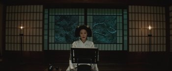 Movie still from “The Handmaiden” (2016), directed by Park Chan-wook – A woman wearing a hat sitting in front of a computer screen; Medium shot, Low angle
