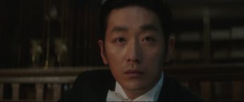 Movie still from “The Handmaiden” (2016), directed by Park Chan-wook – A person wearing a suit and bow tie; Close Up shot, Low angle