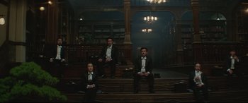 Movie still from “The Handmaiden” (2016), directed by Park Chan-wook – A group of men sitting on top of a wooden staircase; Wide shot, Low angle