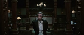 Movie still from “The Handmaiden” (2016), directed by Park Chan-wook – An older man in a suit and white tie; Medium shot, Low angle